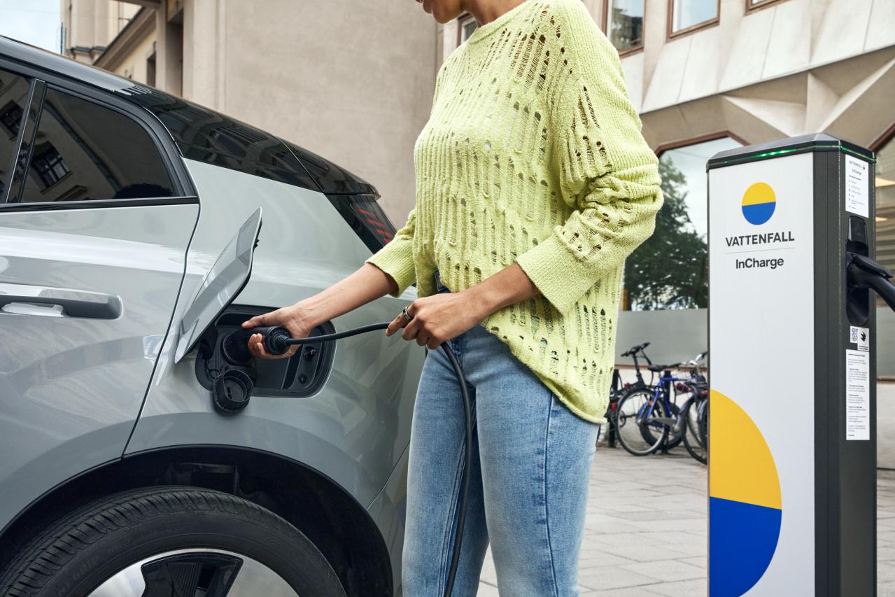 Frau lädt E-Auto